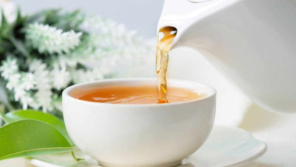 Tasse de thé fumante récupération sportive avec équipement trail arrière-plan